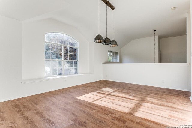 unfurnished dining area featuring lofted ceiling and hardwood / wood-style flooring