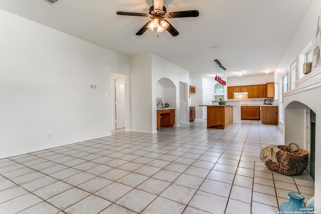 unfurnished living room featuring ceiling fan and light tile patterned floors