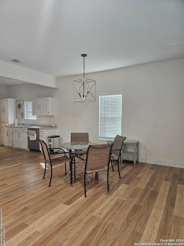 dining space featuring a chandelier, light hardwood / wood-style floors, and a wealth of natural light