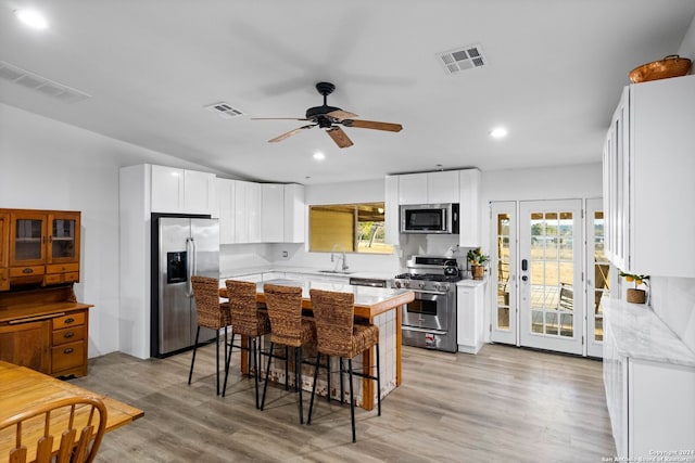 kitchen featuring a healthy amount of sunlight, white cabinetry, and stainless steel appliances