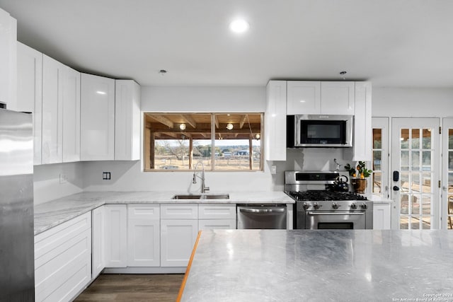 kitchen featuring sink, white cabinets, stainless steel appliances, and plenty of natural light