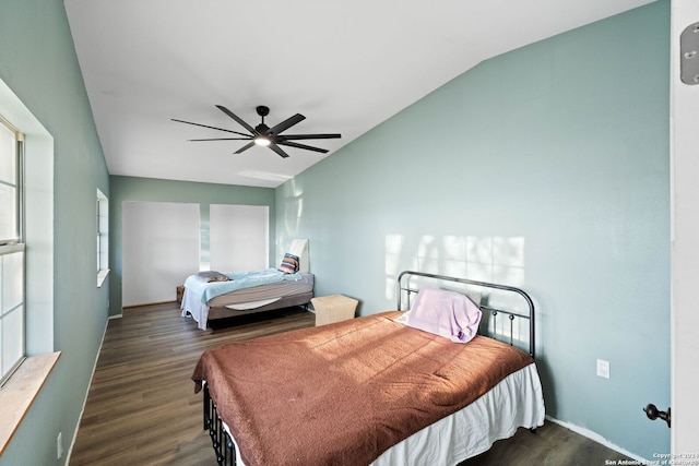 bedroom with ceiling fan, lofted ceiling, and dark wood-type flooring