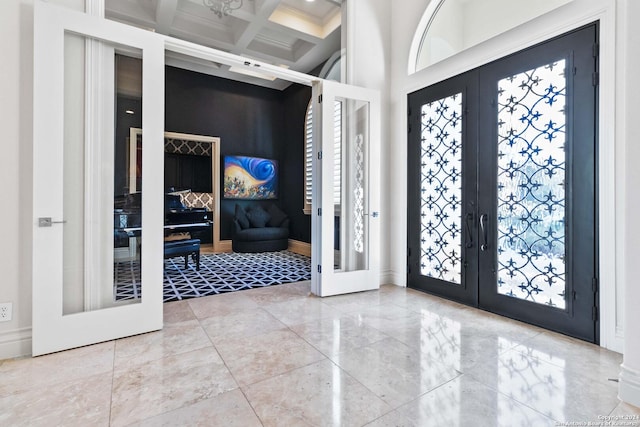 entrance foyer with french doors, beam ceiling, a high ceiling, coffered ceiling, and baseboards