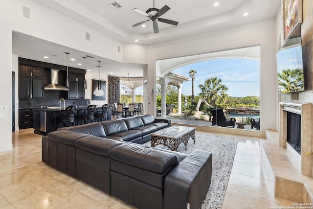 living room featuring a high end fireplace, visible vents, a high ceiling, and recessed lighting