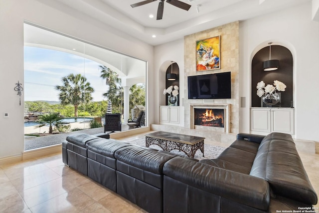 living room featuring ceiling fan, a premium fireplace, built in features, and recessed lighting