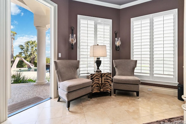 sitting room with a healthy amount of sunlight, ornate columns, and crown molding