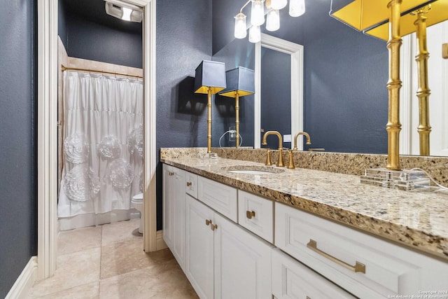 bathroom featuring baseboards, vanity, toilet, and tile patterned floors