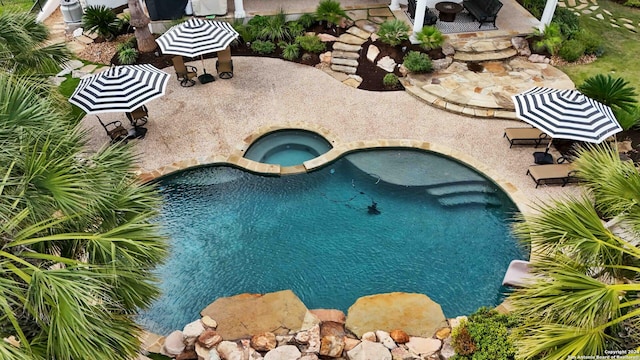 outdoor pool featuring a patio and an in ground hot tub