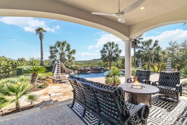 view of patio / terrace featuring ceiling fan and an outdoor fire pit