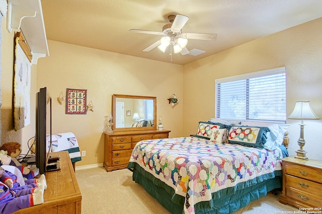 bedroom with light carpet and ceiling fan