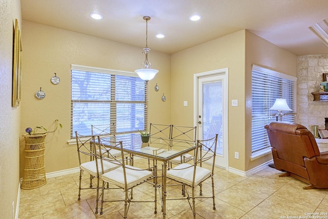 tiled dining area featuring a stone fireplace