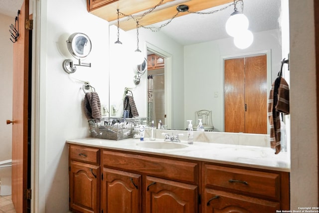 bathroom featuring vanity, a textured ceiling, and toilet