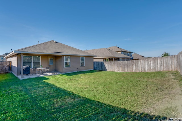 back of property with a lawn and a patio