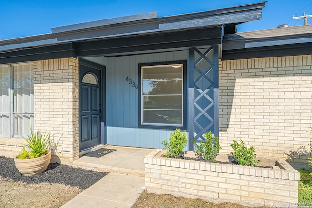 view of exterior entry with a porch