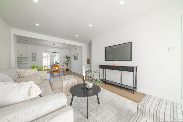 living room featuring light hardwood / wood-style flooring and an inviting chandelier