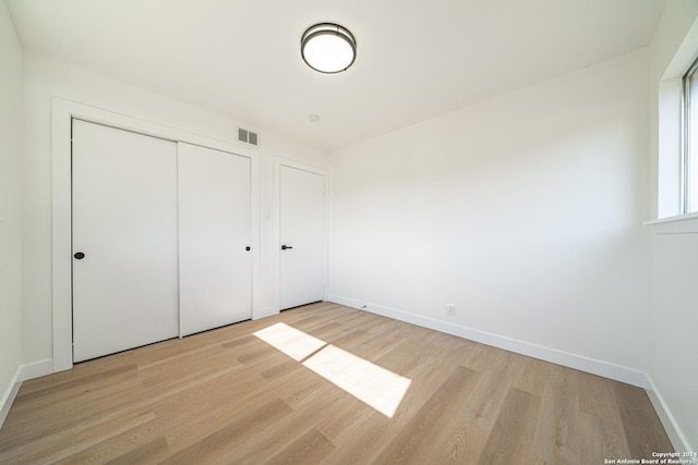 unfurnished bedroom featuring a closet and light hardwood / wood-style floors