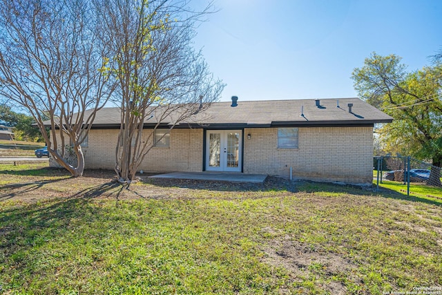 rear view of house with a lawn, a patio area, and french doors