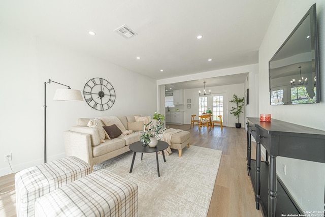 living room with a chandelier and light hardwood / wood-style floors