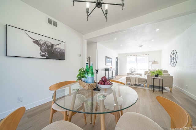 dining room featuring wood-type flooring and an inviting chandelier