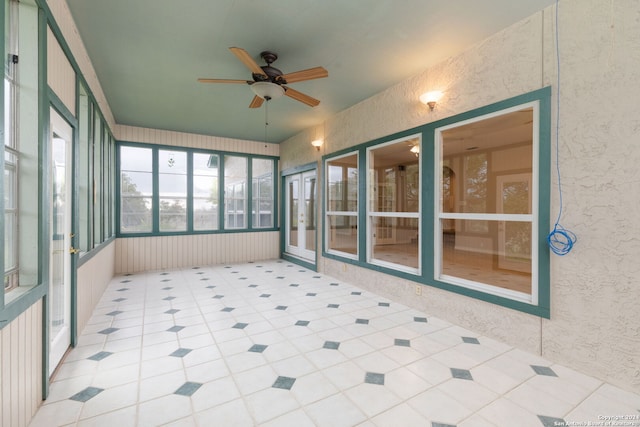 unfurnished sunroom featuring ceiling fan