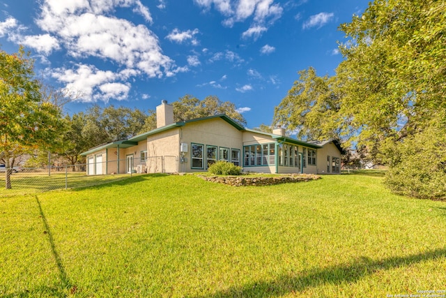 rear view of property featuring a lawn