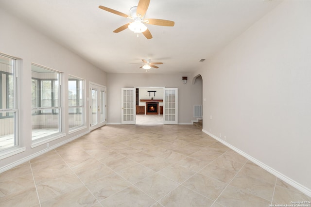 unfurnished living room with ceiling fan, french doors, and light tile patterned floors