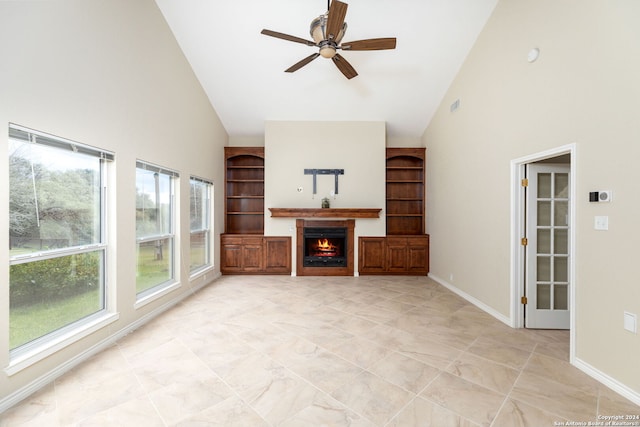 unfurnished living room with ceiling fan, a healthy amount of sunlight, and high vaulted ceiling