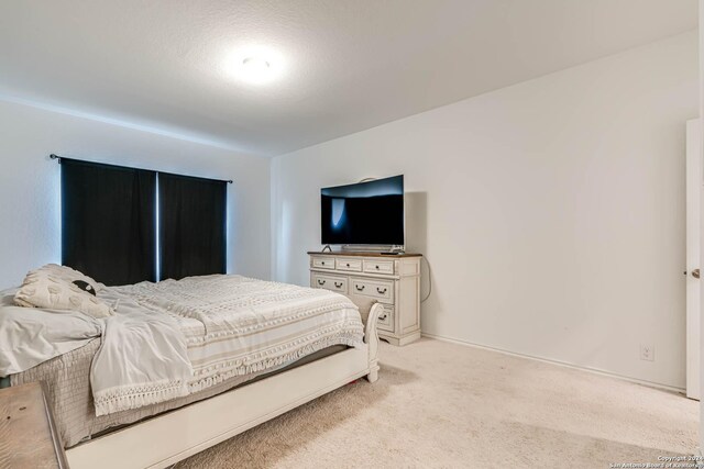 bedroom featuring a textured ceiling and light carpet