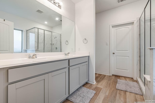 bathroom with hardwood / wood-style floors, vanity, and walk in shower