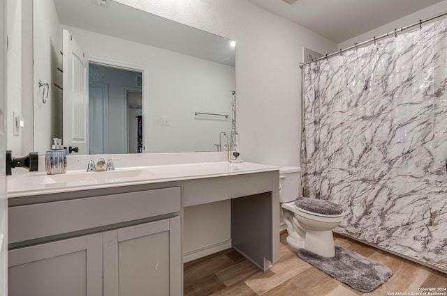 bathroom with vanity, hardwood / wood-style flooring, toilet, and walk in shower