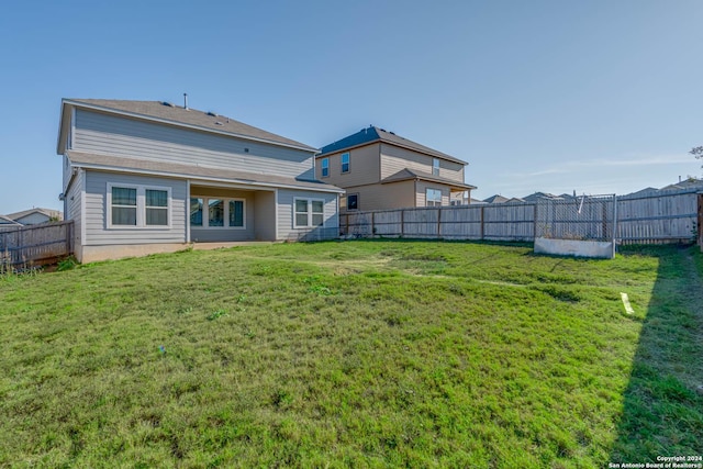 back of house featuring a lawn