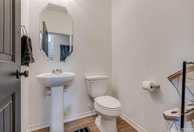 bathroom featuring hardwood / wood-style flooring and toilet