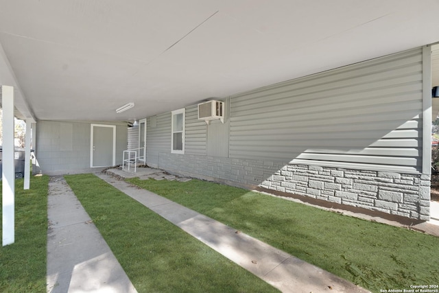 doorway to property with a yard and a wall mounted AC