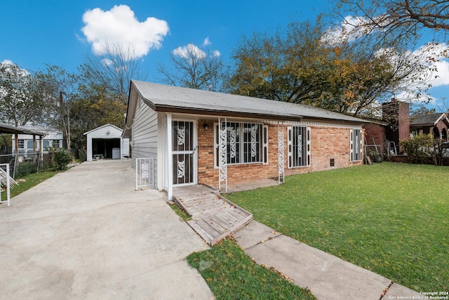 view of front of home featuring an outbuilding, a front lawn, and a garage