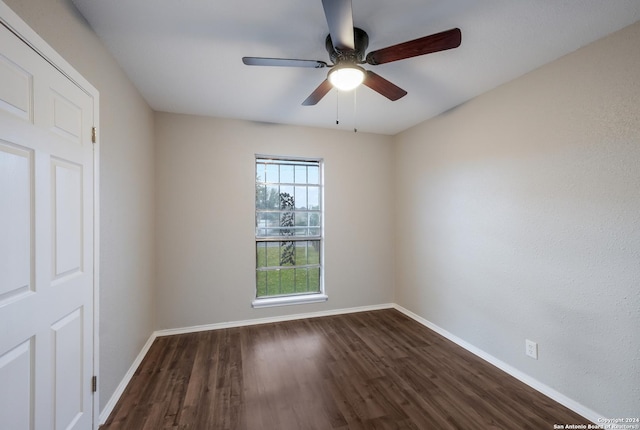 unfurnished room featuring ceiling fan and dark wood-type flooring