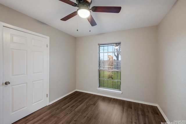 empty room featuring dark hardwood / wood-style flooring and ceiling fan