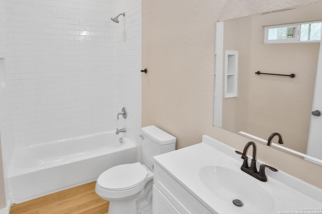 full bathroom with hardwood / wood-style floors, vanity, toilet, and tiled shower / bath