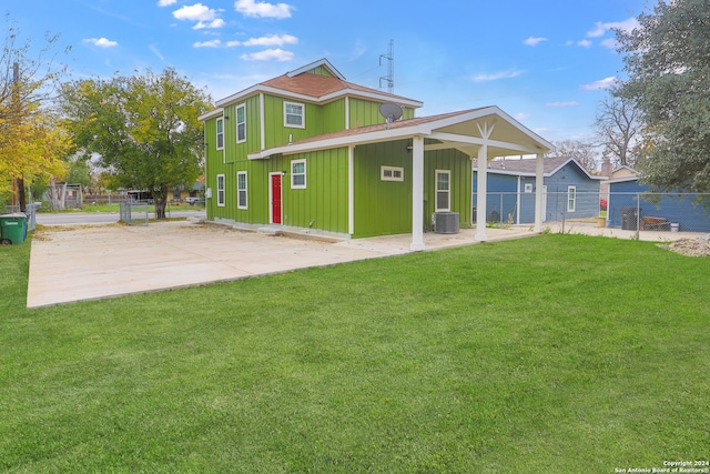 rear view of property featuring a yard and central air condition unit