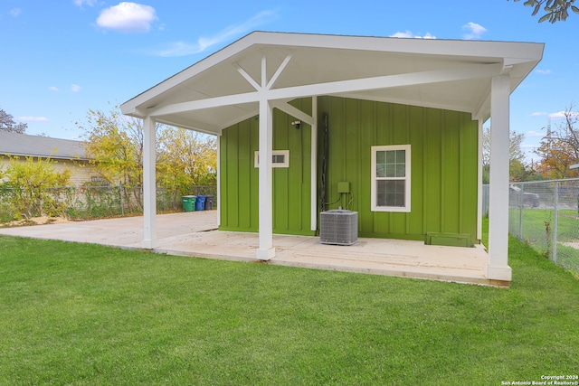 back of property featuring a lawn and central air condition unit