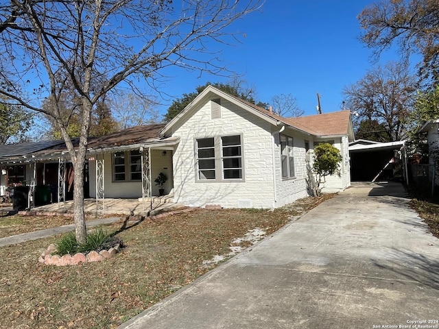 ranch-style house with a carport and covered porch