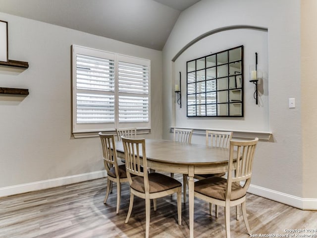 dining area featuring light hardwood / wood-style floors and lofted ceiling