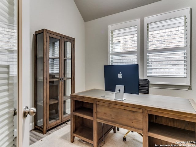 office with light hardwood / wood-style flooring and lofted ceiling