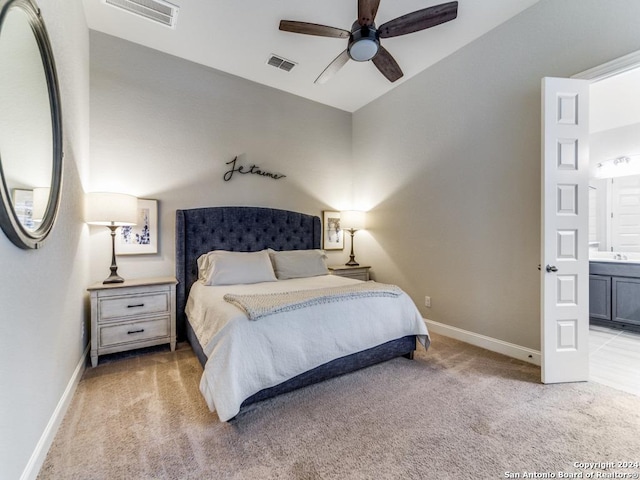 bedroom featuring connected bathroom, light colored carpet, ceiling fan, and lofted ceiling