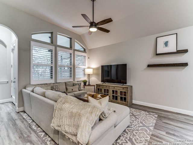 living room with ceiling fan, wood-type flooring, and lofted ceiling