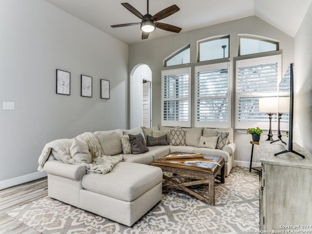 living room featuring light hardwood / wood-style floors, vaulted ceiling, and ceiling fan