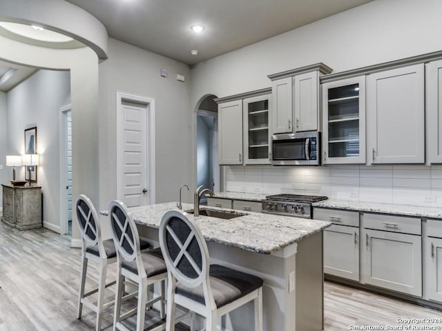 kitchen featuring sink, an island with sink, and stainless steel appliances