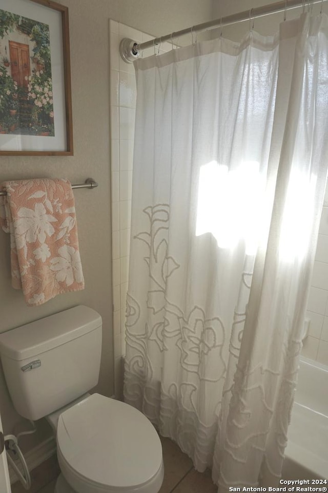 bathroom with shower / bath combination with curtain and toilet