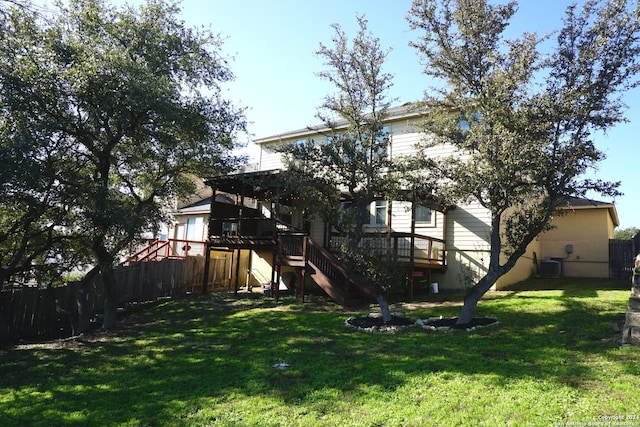 rear view of house featuring a yard, central AC unit, and a wooden deck