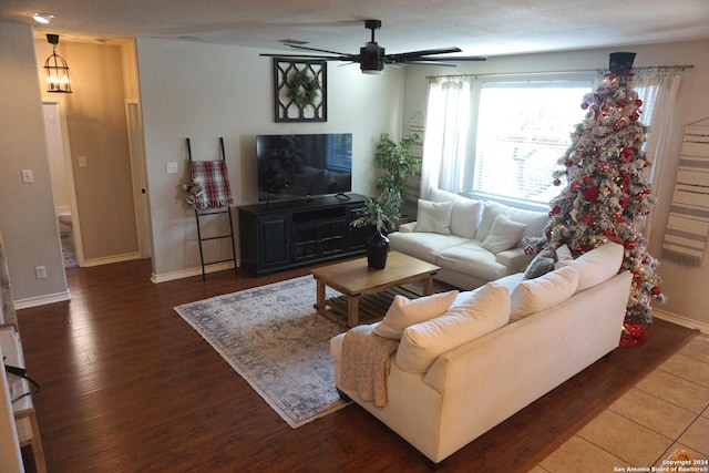 living room with hardwood / wood-style floors and ceiling fan with notable chandelier