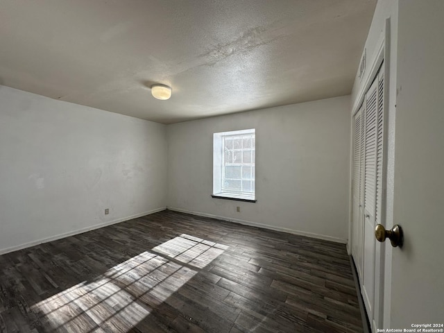 unfurnished bedroom with dark hardwood / wood-style floors and a closet